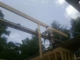 Carpenter setting a ridge beam over a new addition frame — Ice Dam Removal by Roofing Brothers in Paupack