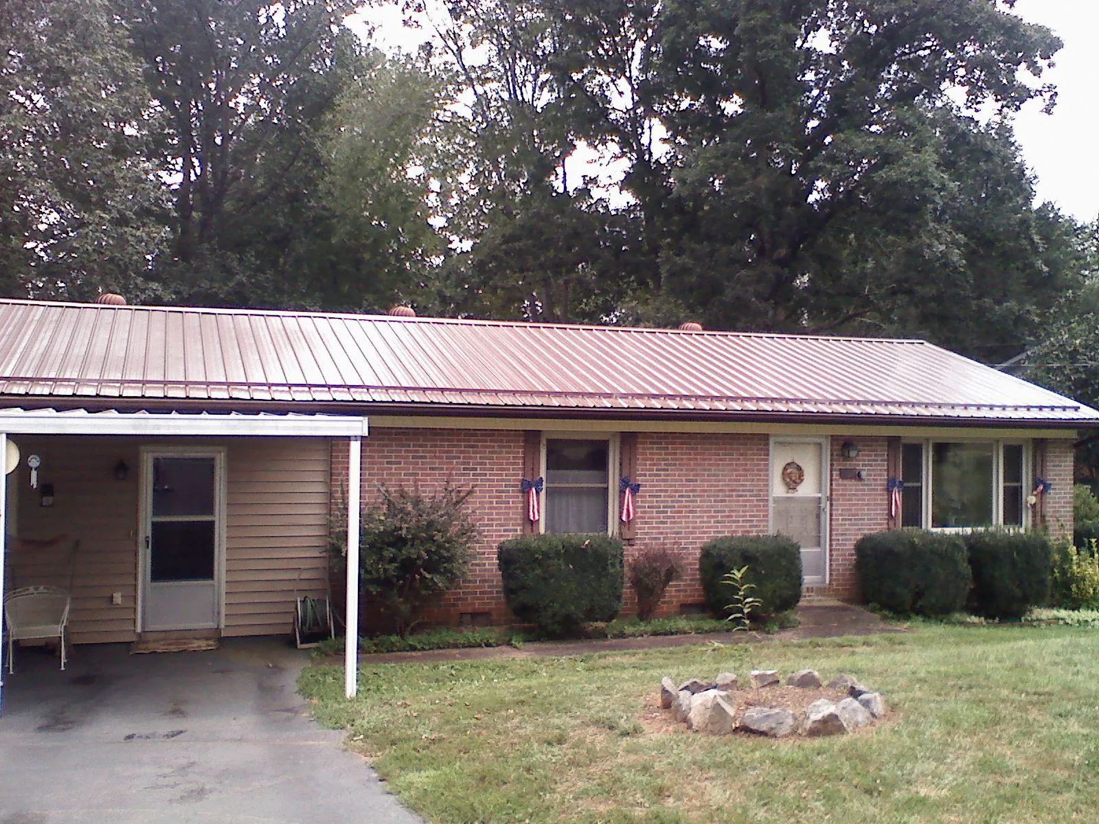 Bronze metal roof and carport on a brick ranch home — Roof Repair work by our crew in Paupack